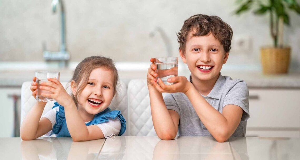 Dzieci piją filtrowaną wodę z dystrybutora
